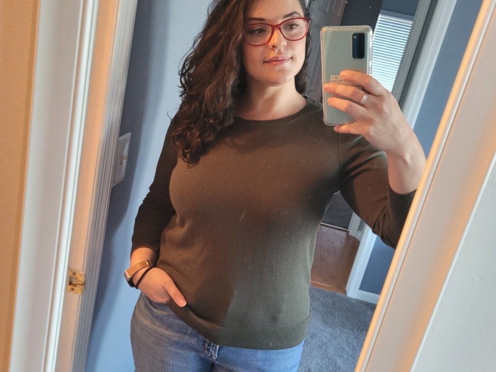 woman in brown sweater taking selfie