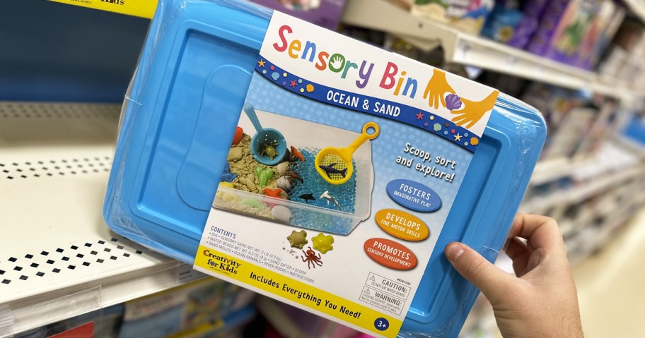 hand grabbing blue sensory bin from shelf