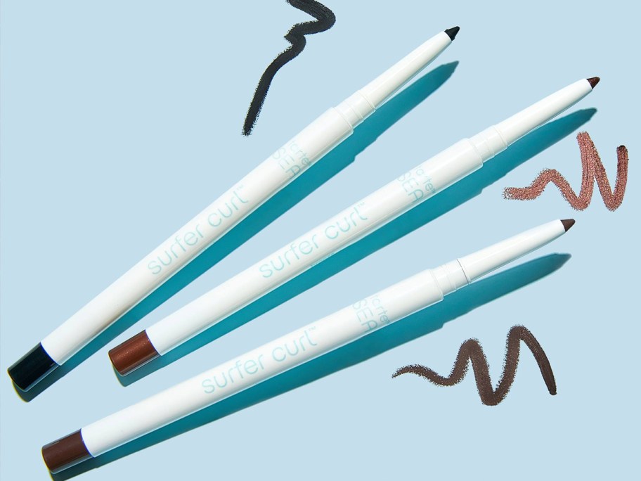 three Tarte Sea Surfer Curl Waterproof Gel Liners on blue background