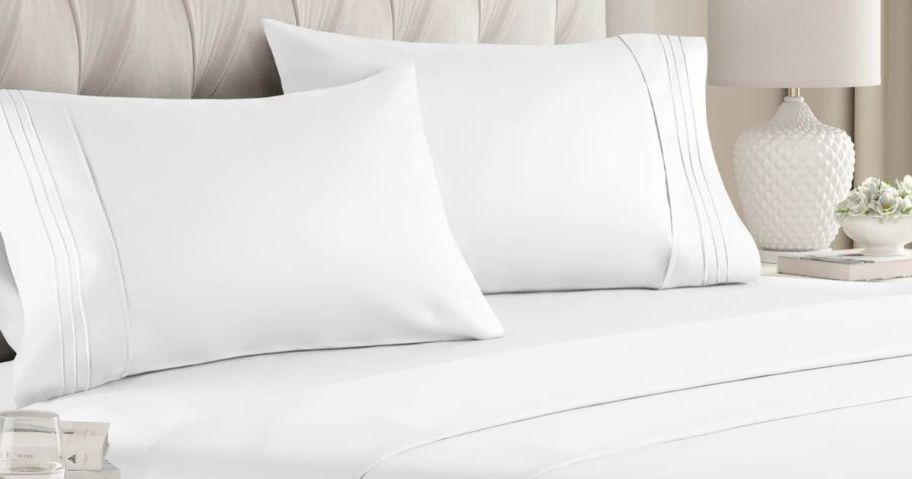 a bed with white sheets and pillows with white pillowcases