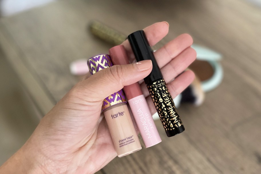 hand holding 3 mini tarte products