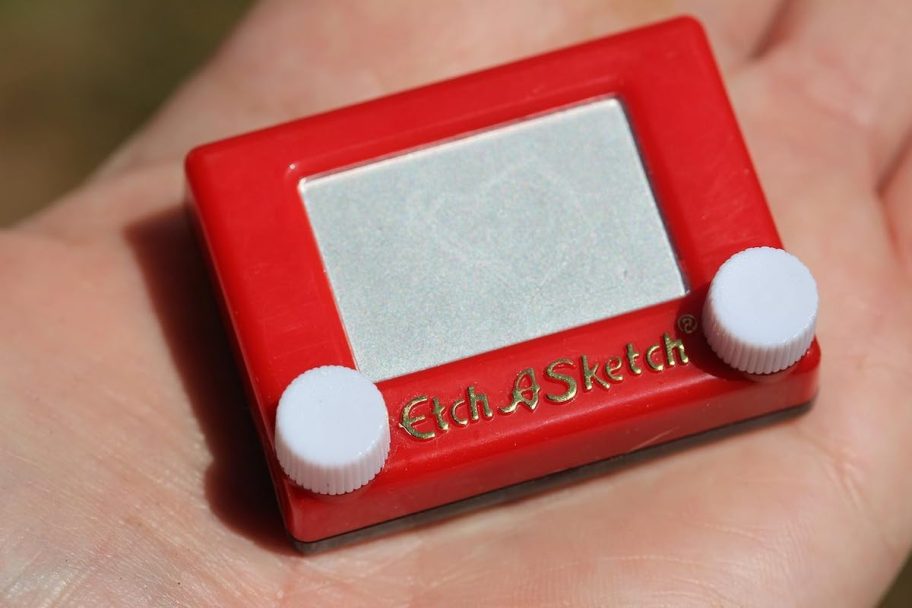 close up of palm of hand holding mini etch a sketch