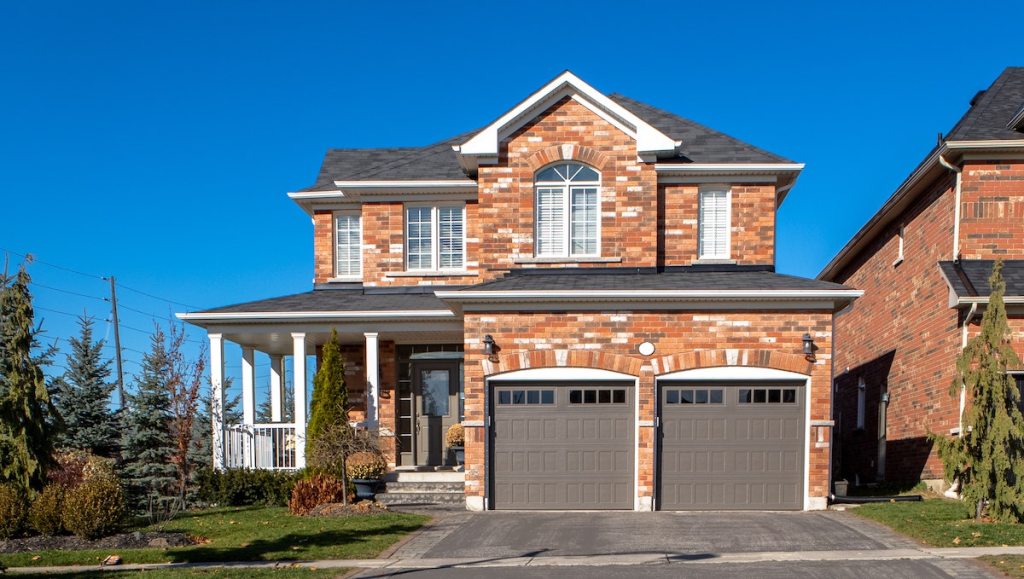front of brick house with two car garage 