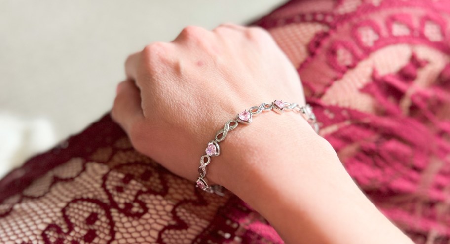 woman wearing a cate & chloe bracelet with pink diamonds. 