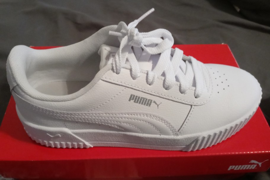 white shoe on top of red shoebox