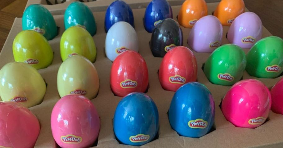 a 24-count pack of Play Doh filled plastic easter eggs in a carton