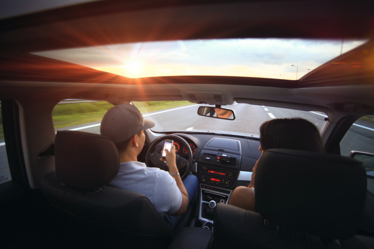 Two people driving in a car and only one is the designated driver because that's the cheapest way to rent a car