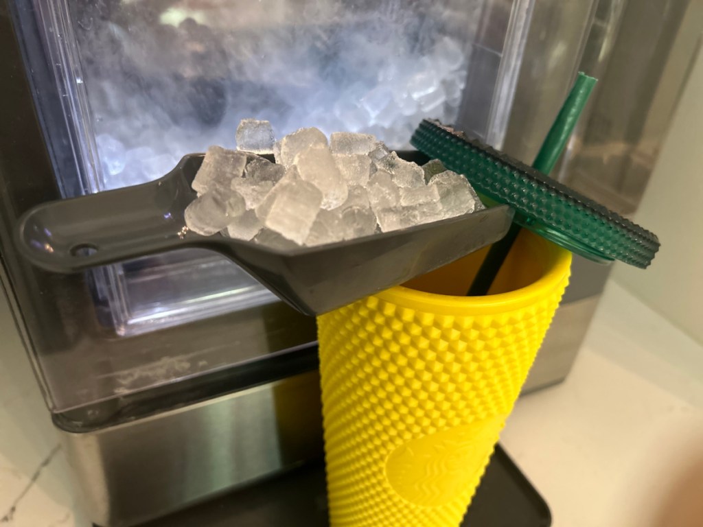 someone scooping nugget ice into yellow starbucks cup