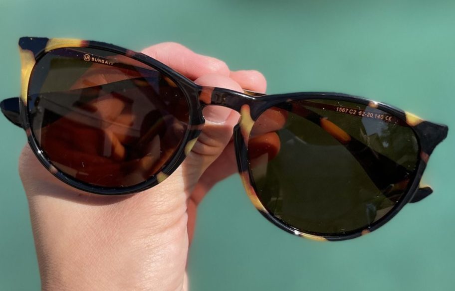 Hand holding a pair of Sungait Sunglasses