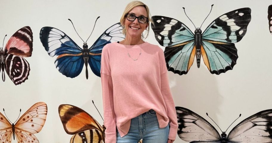 Collin wearing wearing a pink Time and Tru Women's High Low Pullover Sweatshirt in front of buttefrly wallpaper wall