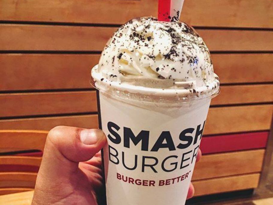 A person holding a Smashburger Milkshake