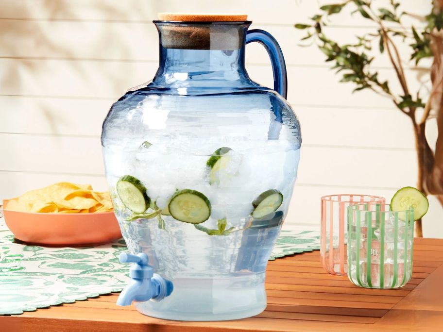 blue beverage dispenser on table with sliced limes in it