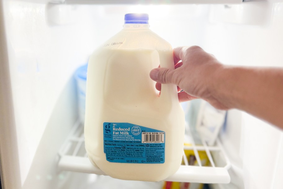 hand placing milk in freezer
