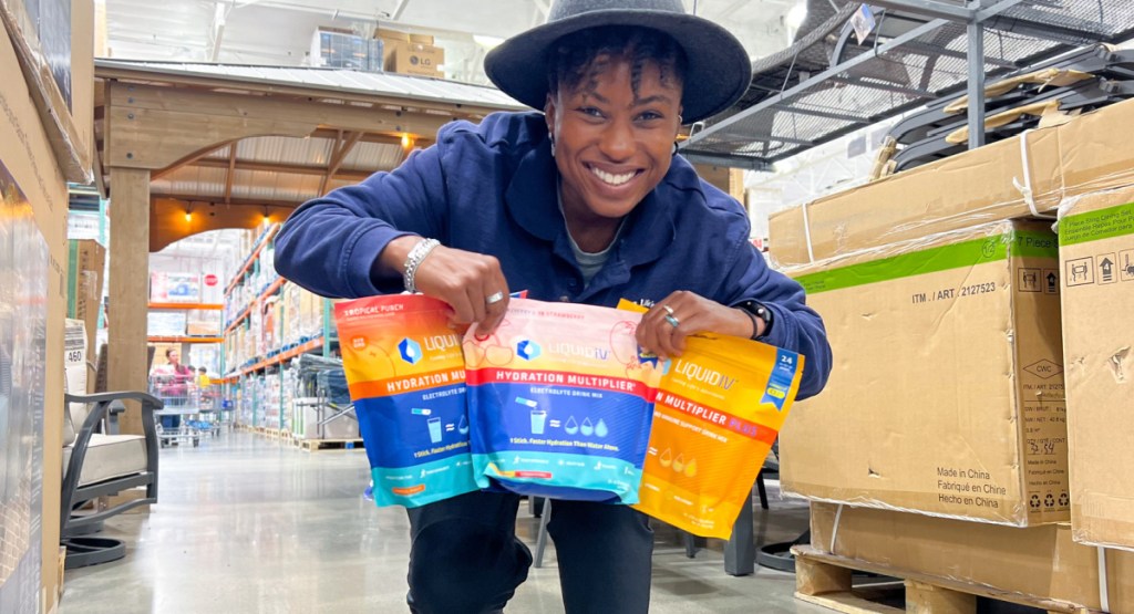 woman holding 3 different liquid IV packs in their hands