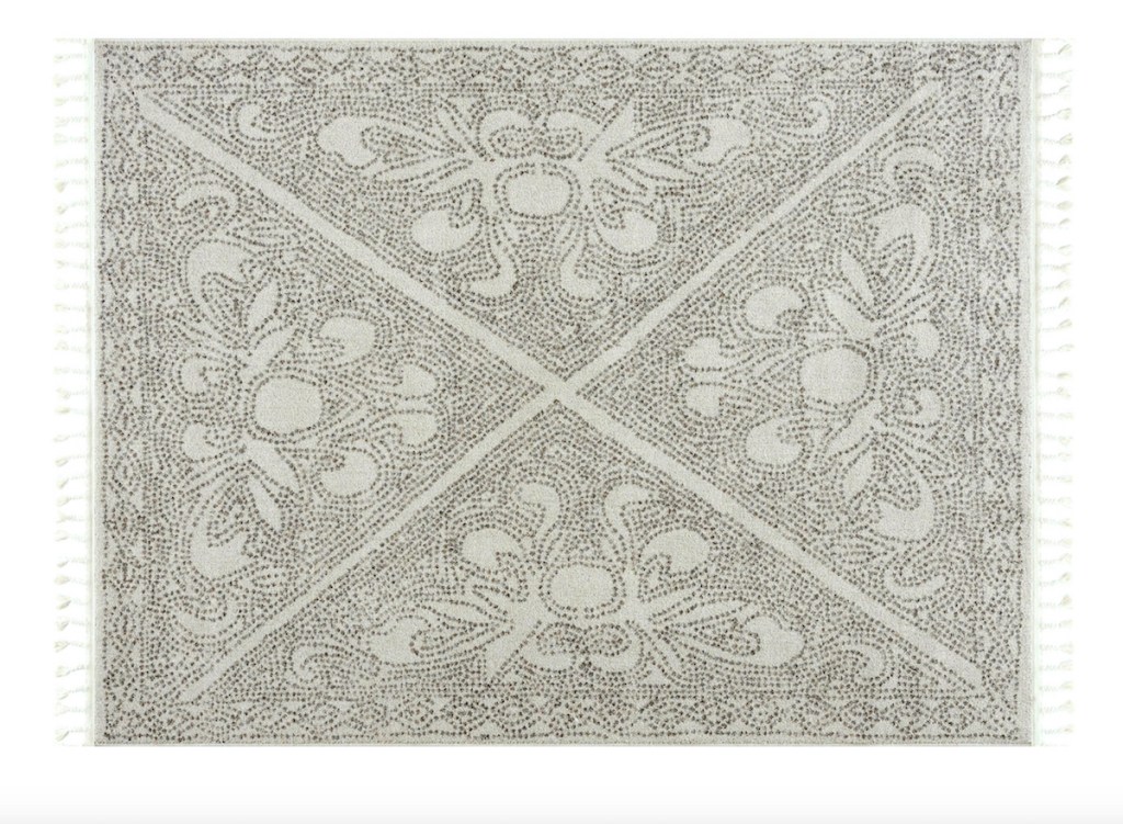 gray and white pattern rug on white background with tassels