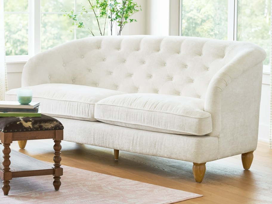 white upholstered sofa with tall tufted back