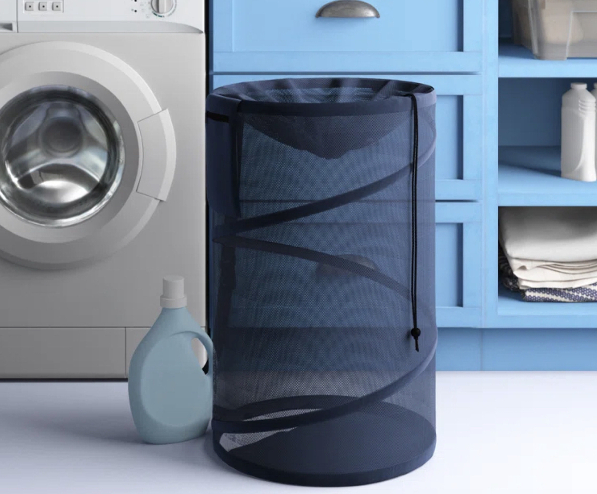 navy blue laundry basket sitting on floor in laundry room