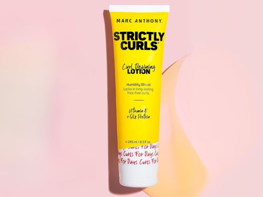 Marc Anthony Curl Defining & Enhancing Lotion bottle on pink background