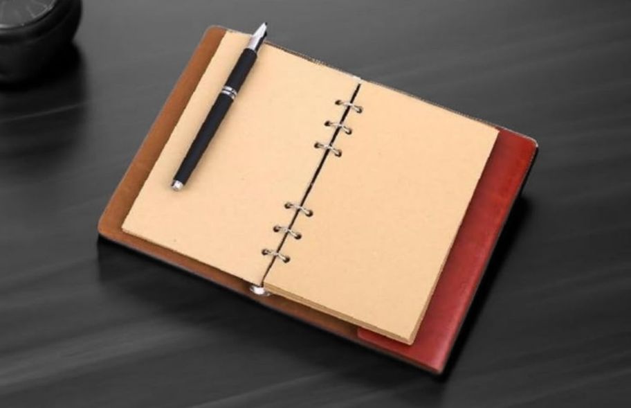 a small journal on a table open to a blank page
