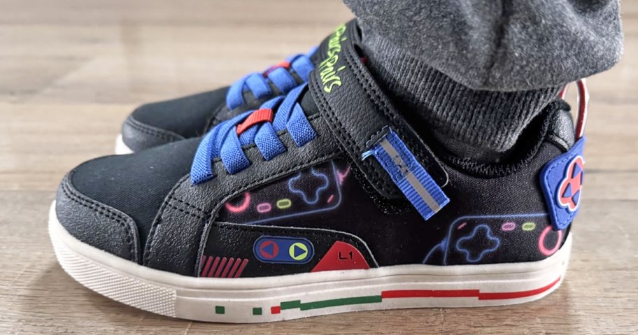 pair wearing a pair of black gaming controller print sneakers