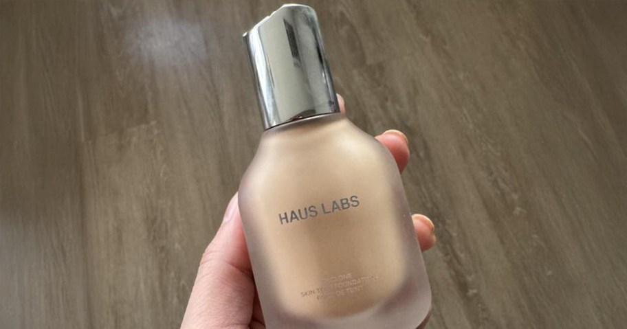 Haus Labs Foundation Bottle being held by a woman
