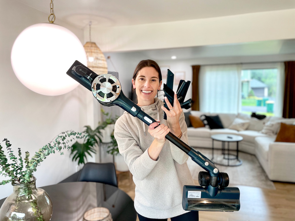woman holding cordless stick vacuum 