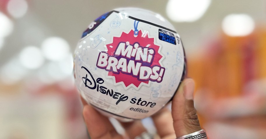 hand holding up a Disney Mini Brands Capsule in store