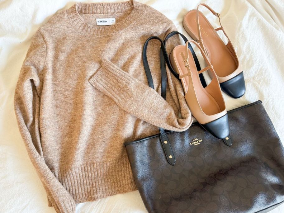 A Sonoma sweateron a bed with slingback flats and a coach handbag