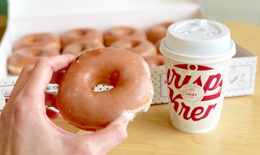 hand holding an original glazed krispy kreme doughnut, one of the birthday freebies and free birthday stuff you can get in 2025