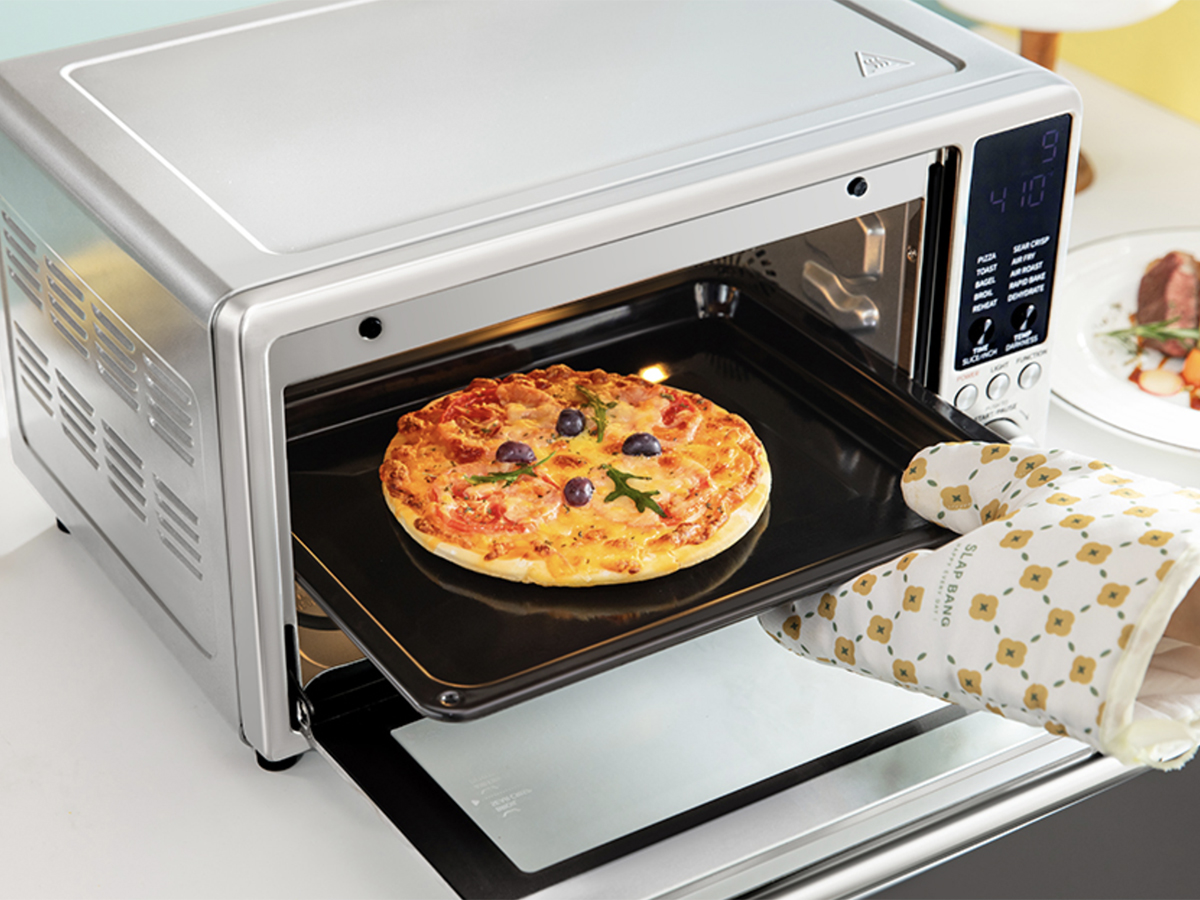 hand taking pizza out of comfee oven