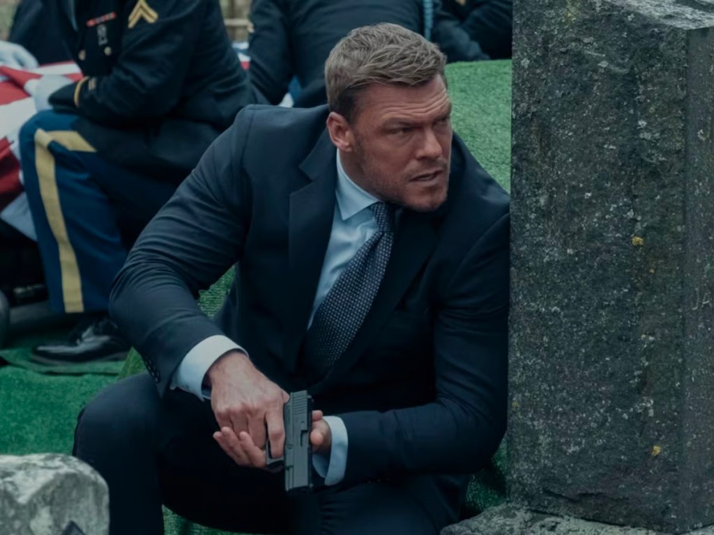 reacher with gun in cemetary
