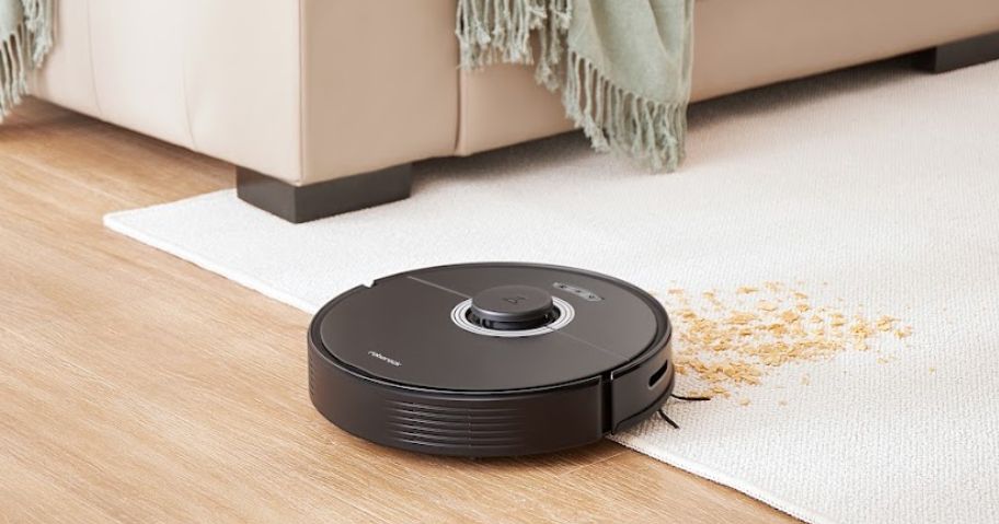 roborock robot vacuum cleaning up mess on white carpet