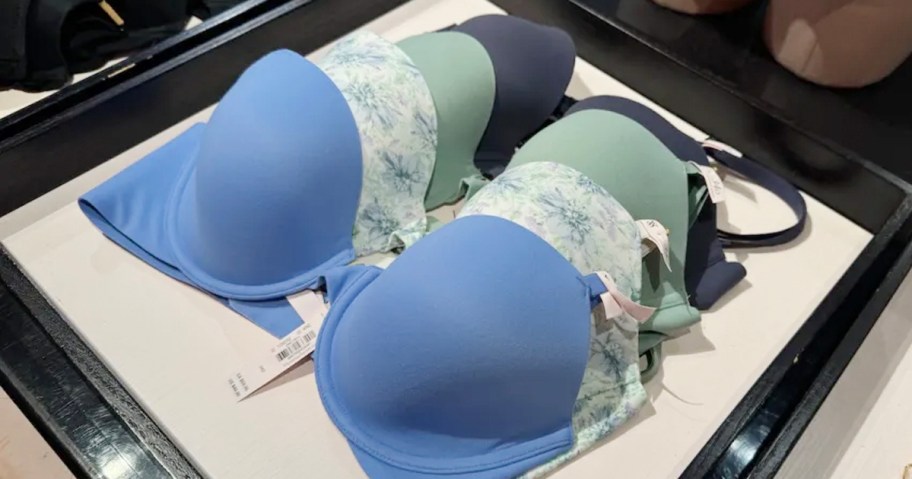 stack of blue victorias secret bras on display 