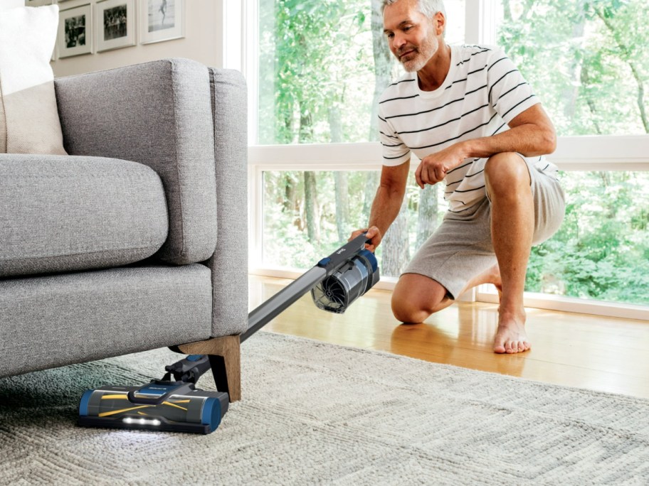 man vacuuming carpet with Shark Pet Pro Cordless Stick Vacuum