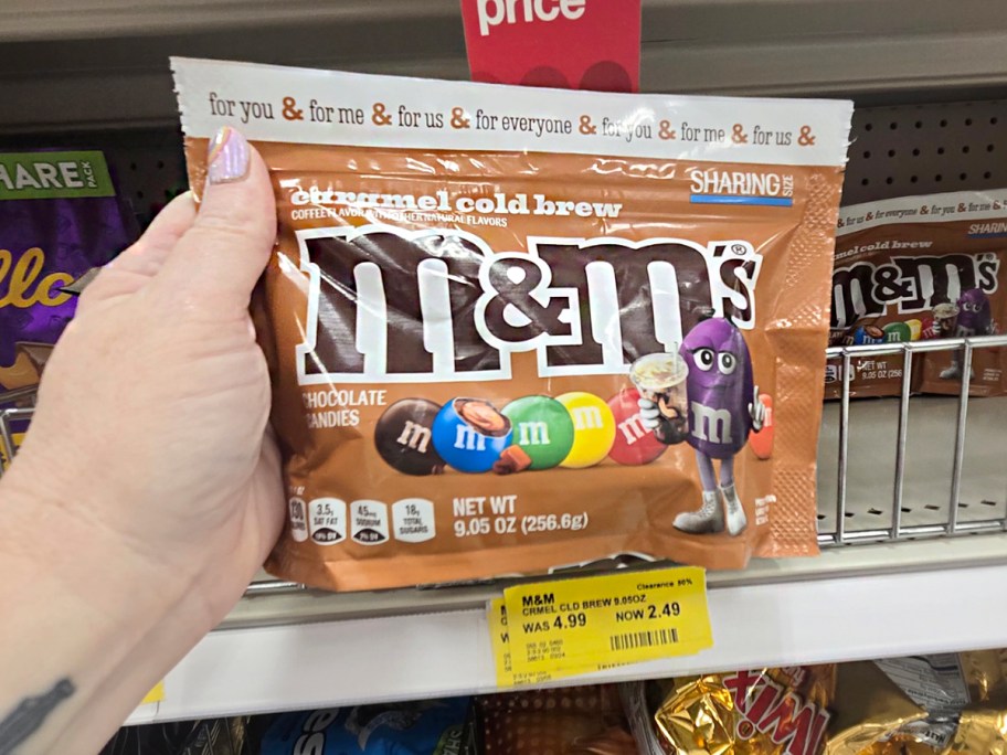 hand holding bag of caramel m&ms