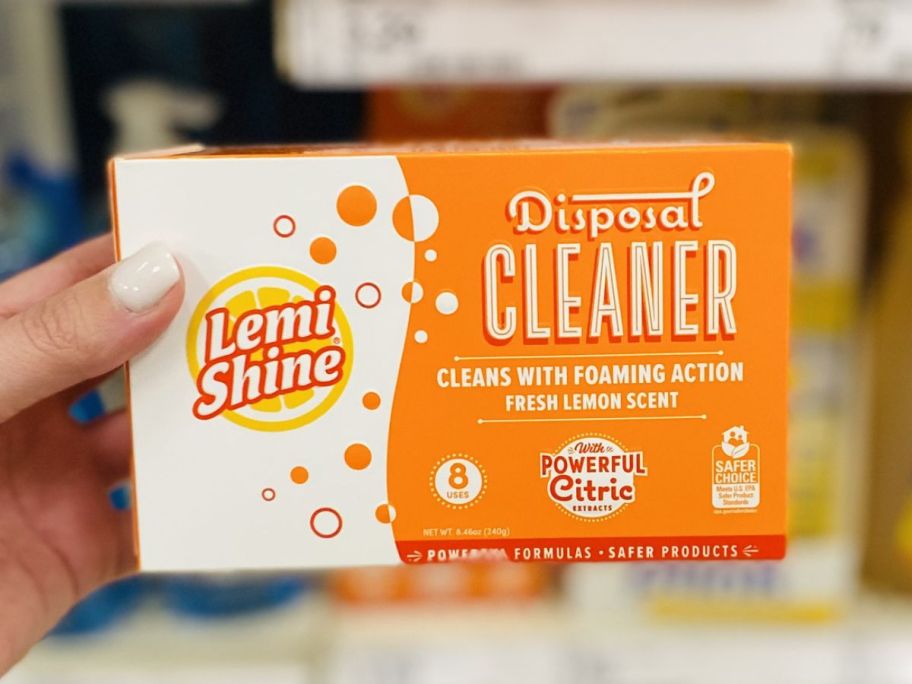 Hand holding a box of Lemi Shine disposal cleaner