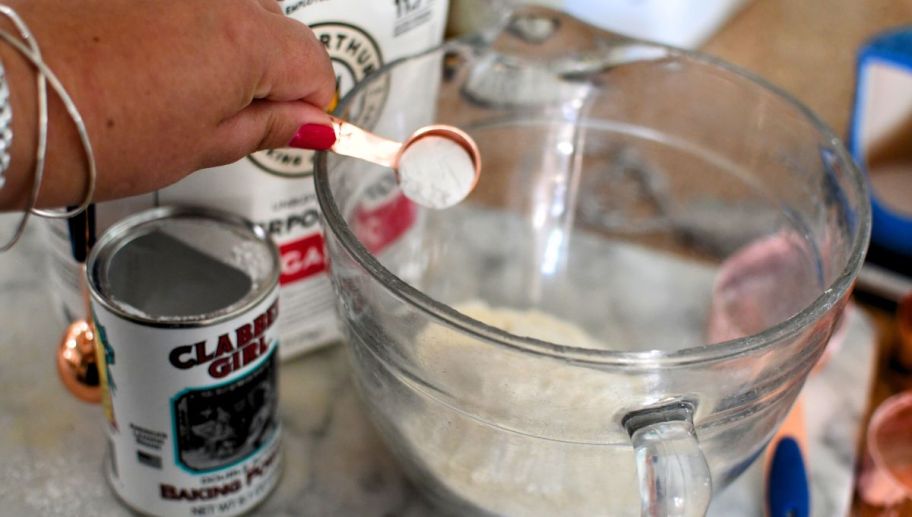adding baking powder to a batter bowl for homemade pan cake batter