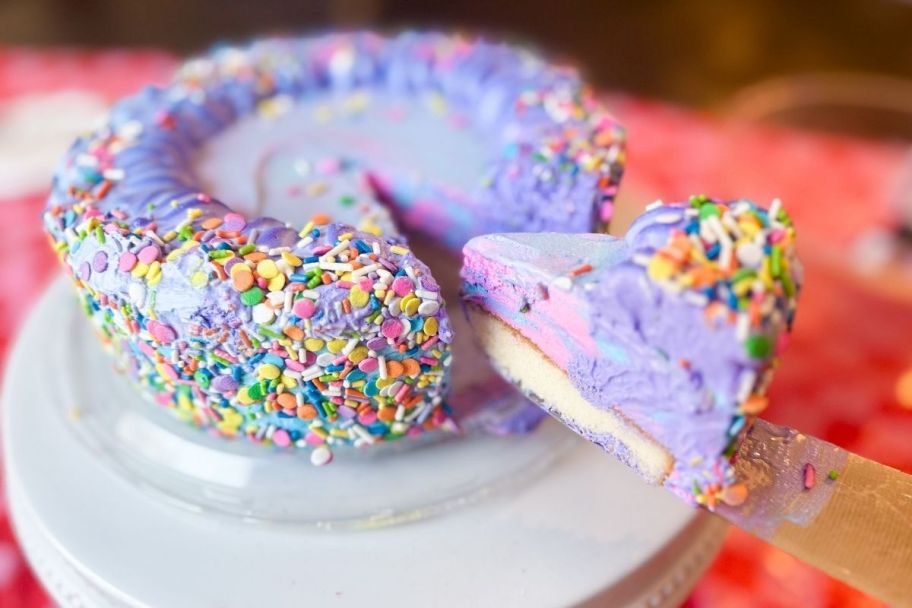 a unicorn icecream cake with a slice being removed