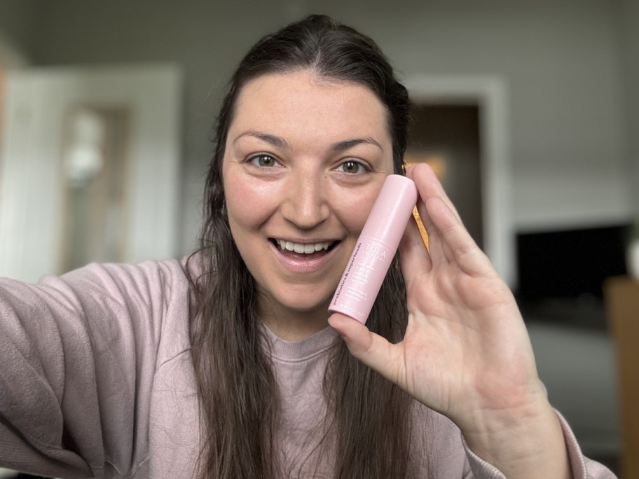 woman holding a TULA eye balm stick