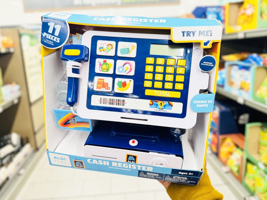 hand holding up a play cash register