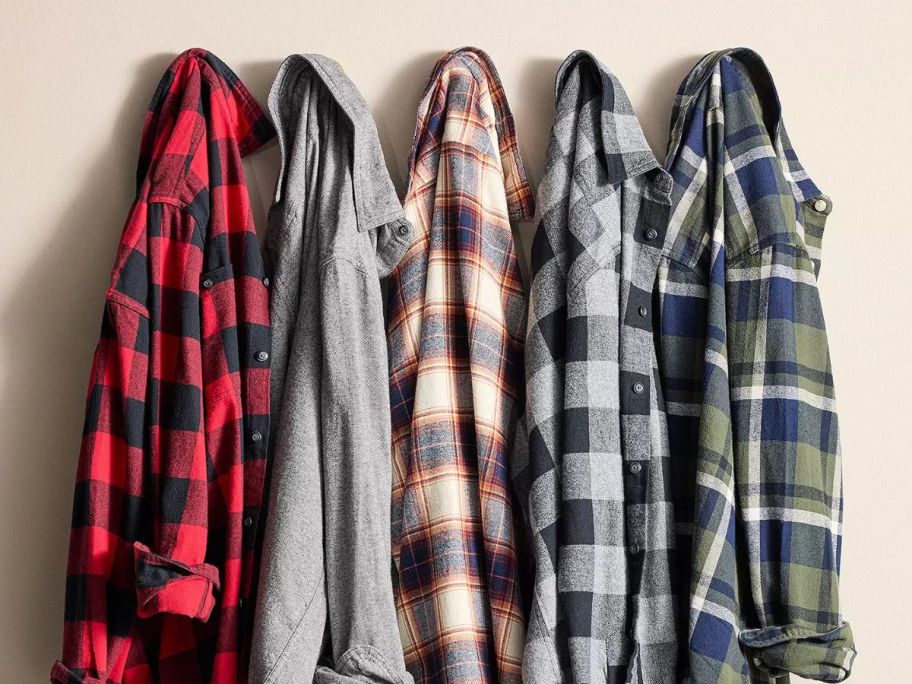 5 flannel shirts hanging on a wall