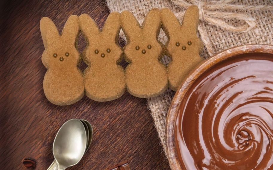 4 chocolate pudding bunny peeps next to a bowl of chocolate pudding