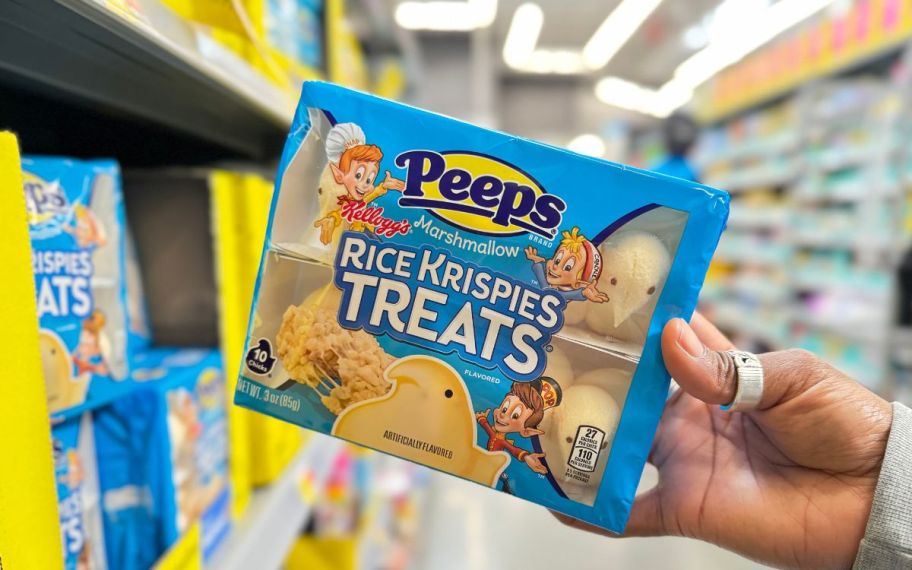 a womans hand holding a package of peeps rice Krispies treats 