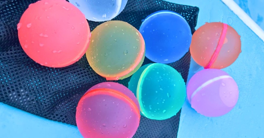 colorful Magnetic Reusable Water Balloons laying on a mesh bag on the pavement