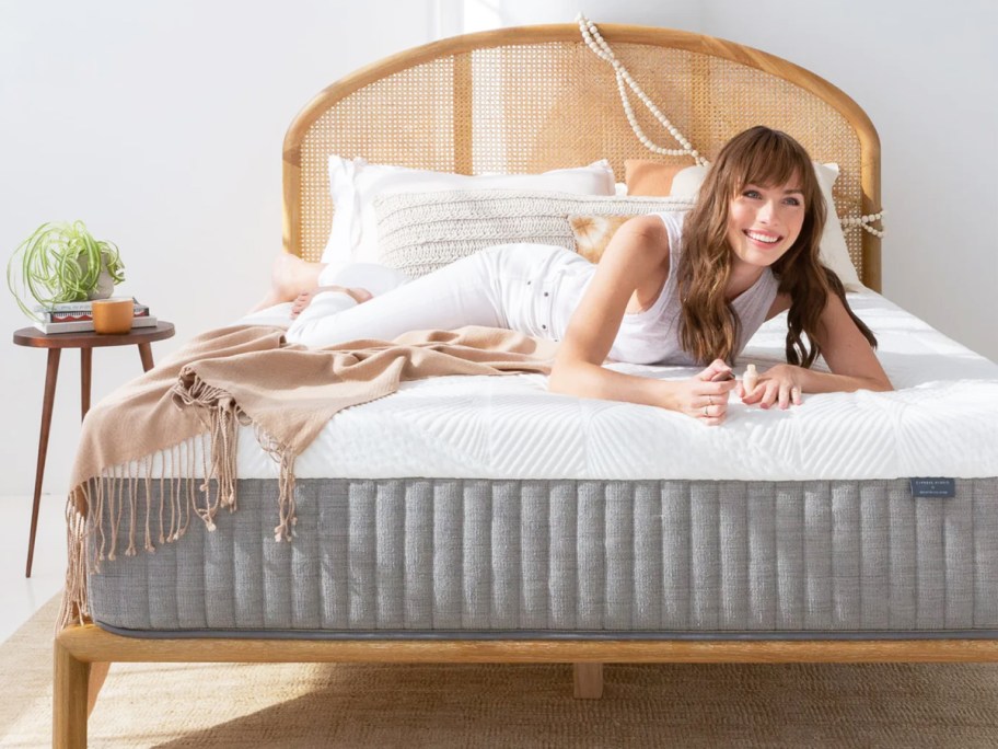 woman laying on top of white and grey mattress