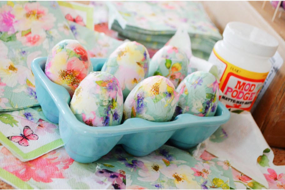 DIY dcoupage eggs in blue egg tray next to mod podge