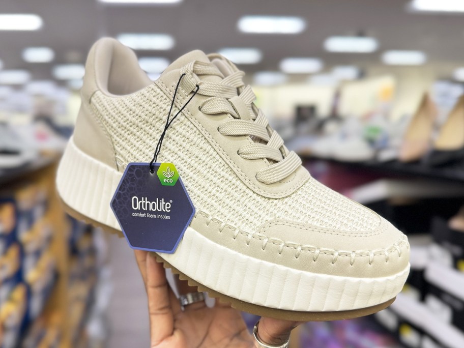 woman holding up a platform sneaker in store