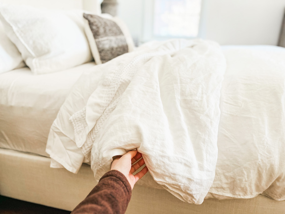 hand holding edge of white duvet