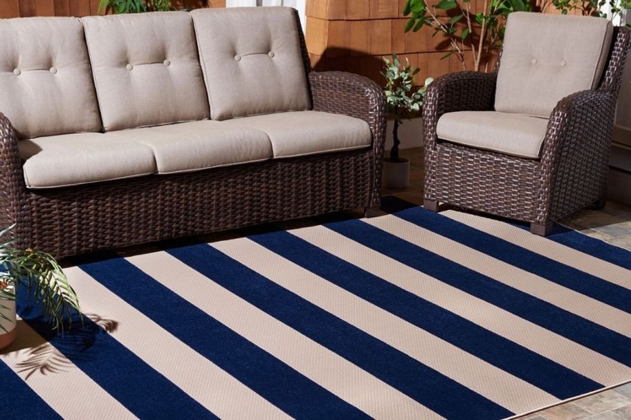 a blue and white striped outdoor rug shown with a sofa and chair
