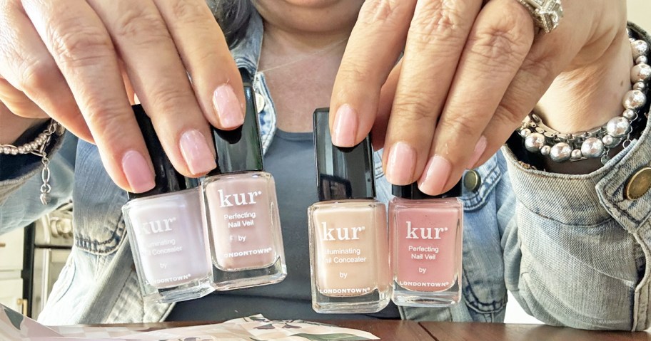 woman holding up 4 bottles of Londontown nail polish